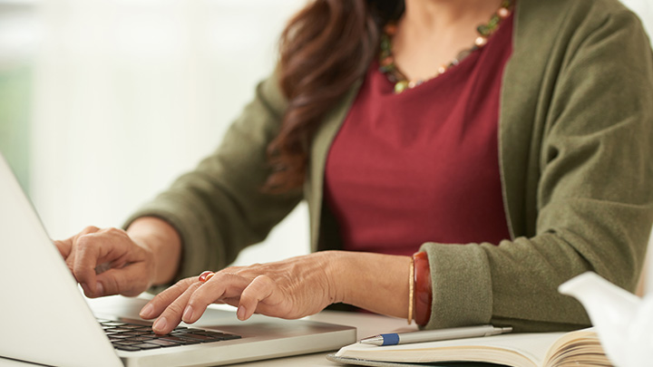 Close up of a woman's hands on a laptop