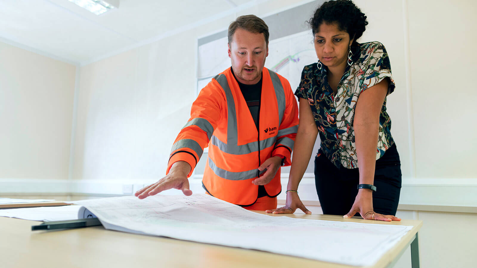 Two people looking at plans on paper