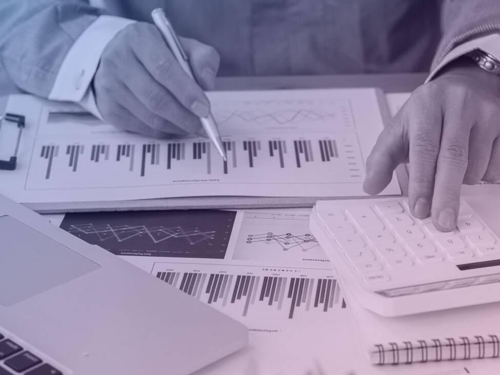 a man working with spreadsheets and a calculator